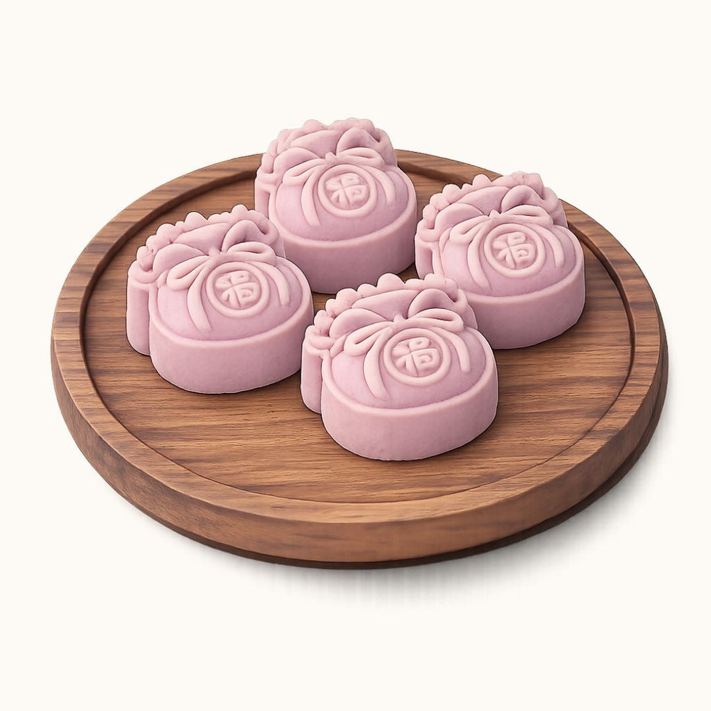 Four pink mooncakes with embossed Chinese characters, arranged on a round wooden tray against a light cream background.